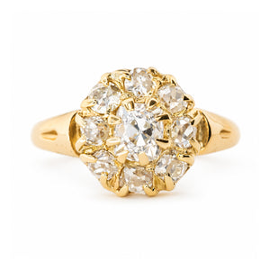 An antique Victorian yellow gold diamond cluster engagement ring against a plain white background.