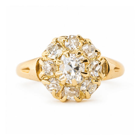 An antique Victorian yellow gold diamond cluster engagement ring against a plain white background.