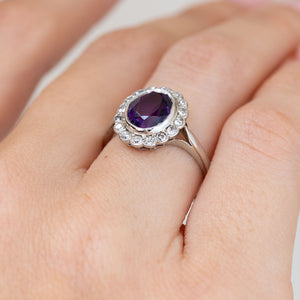 Viewed obliquely on the finger, the antique ring reveals its raised setting, milgrain border and slender white gold shank.