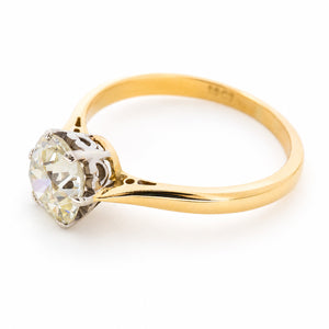 A side profile of an antique engagement ring with platinum and gold set to centre a yellow tinted cushion-shaped old-cut diamond.