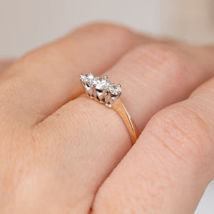 Side angle on the hand revealing the elevated platinum claws and softly tapered yellow gold shoulders.