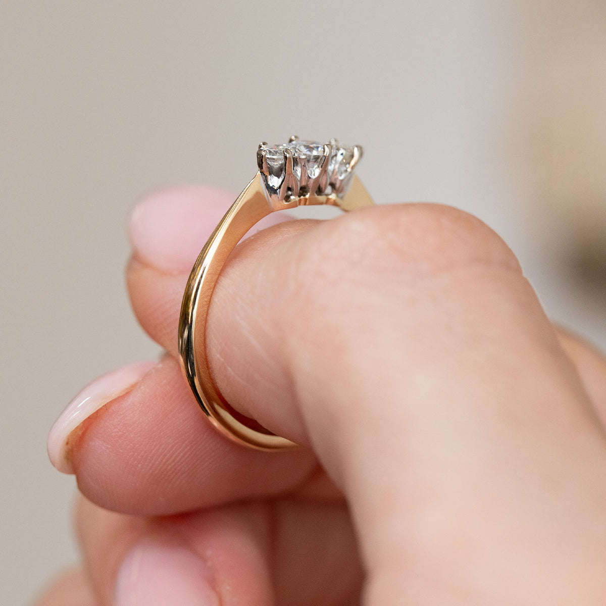 Profile of the Edwardian engagement ring, showing the sculptural platinum setting above its slender yellow gold band.