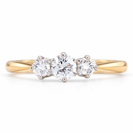 Antique Edwardian diamond three-stone engagement ring, with three claw-set diamonds in platinum on a yellow gold band.