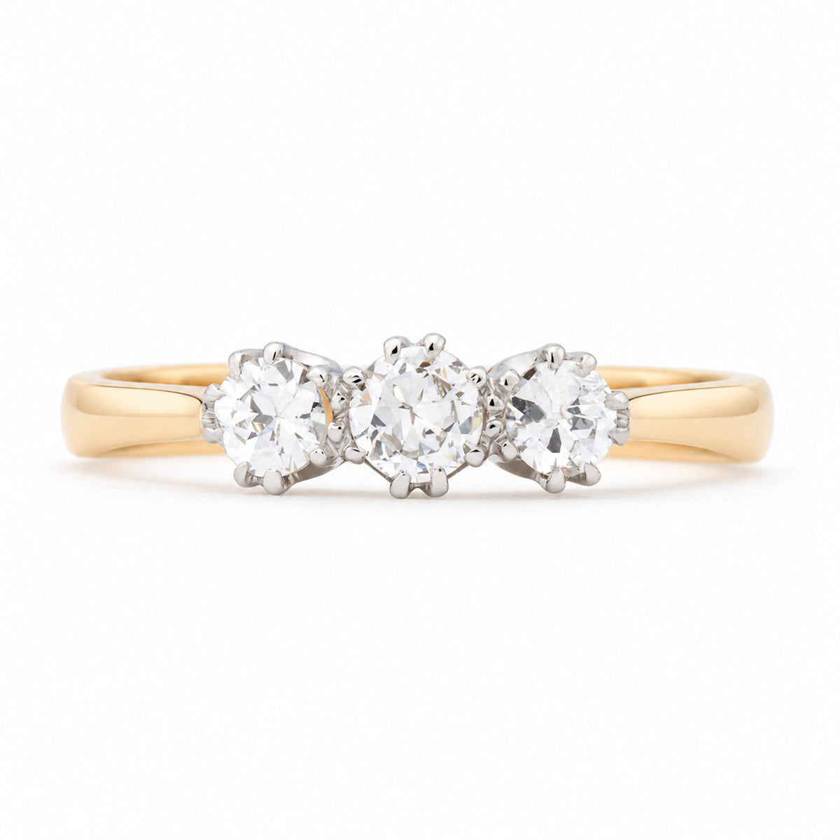 Antique Edwardian old-cut diamond three-stone engagement ring in yellow gold and platinum, featuring three round diamonds in claw settings.