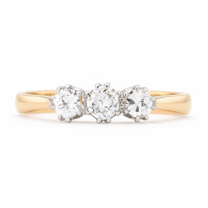 Antique Edwardian old-cut diamond three-stone engagement ring in yellow gold and platinum, featuring three round diamonds in claw settings.