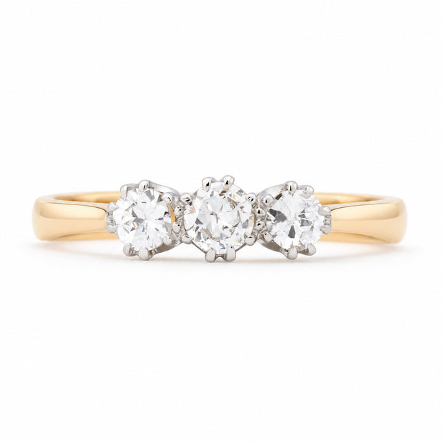 Antique Edwardian old-cut diamond three-stone engagement ring in yellow gold and platinum, featuring three round diamonds in claw settings.