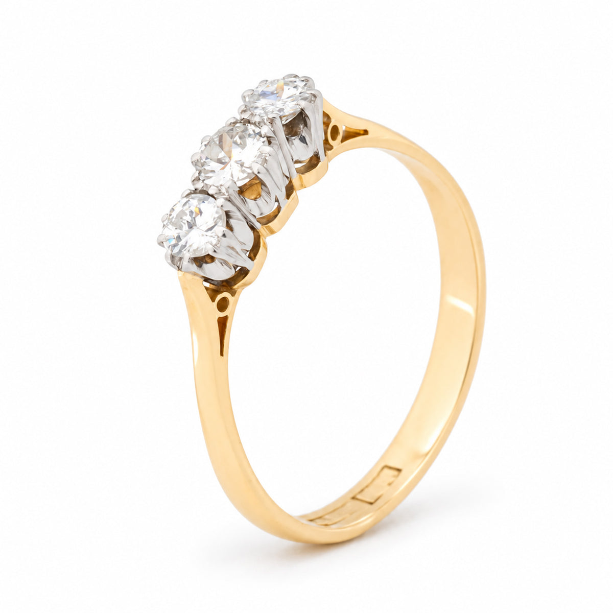 Angled view of the Edwardian diamond ring, highlighting the raised platinum settings and polished yellow gold band.