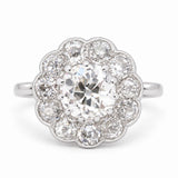 An Antique, Edwardian engagement ring in platinum featuring an old-cut diamond at the centre with a halo of diamonds.