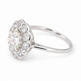An Antique platinum engagement ring with an old-mine cut diamond centre and cluster. 