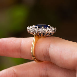 A close-up of a Vintage, 1960s blue sapphire and diamond cluster cocktail ring shown from the side to display the gallery