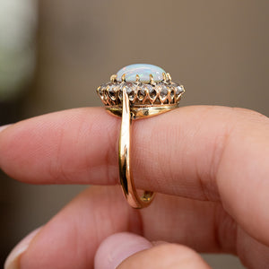 Profile of the Edwardian cluster ring displaying the elevated opal setting, open gallery and slender yellow gold shank.
