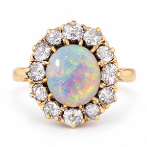 Antique Edwardian opal cabochon and diamond cluster ring in yellow gold, centred with a colourful oval opal surrounded by old-cut diamonds.