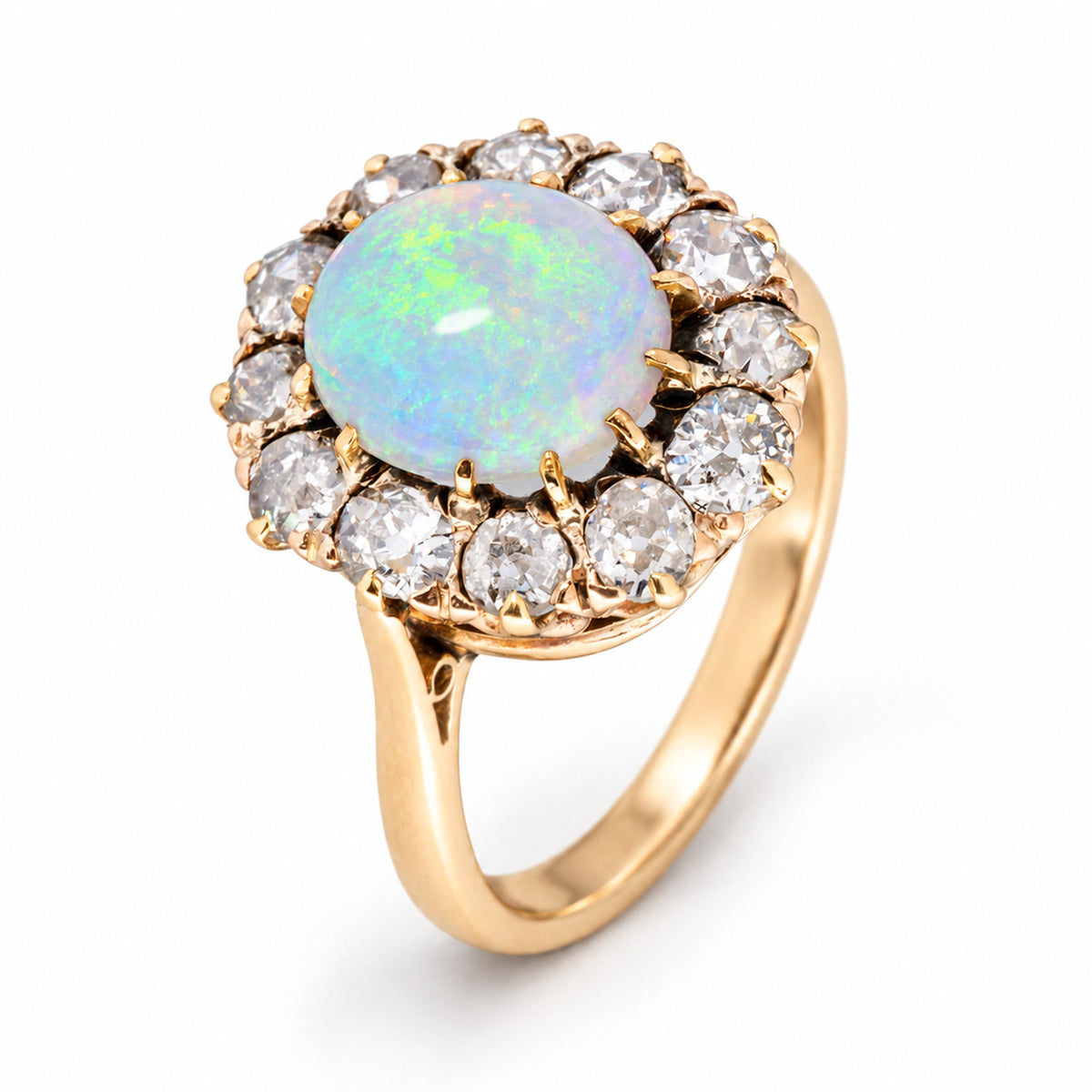 Elevated studio portrait of the Edwardian opal cluster ring, revealing its diamond halo, ornate gallery and polished yellow gold band.