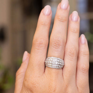 A close-up of a hand wearing a A Vintage, 1950s diamond bombe cocktail ring in white gold 