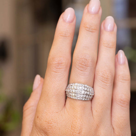 A close-up of a hand wearing a A Vintage, 1950s diamond bombe cocktail ring in white gold 