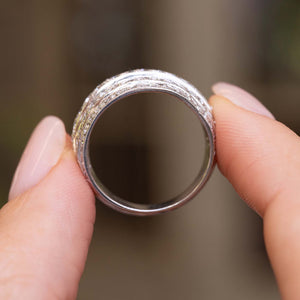 A Vintage, 1950s diamond bombe cocktail ring in white gold held up to show the profile of the ring.