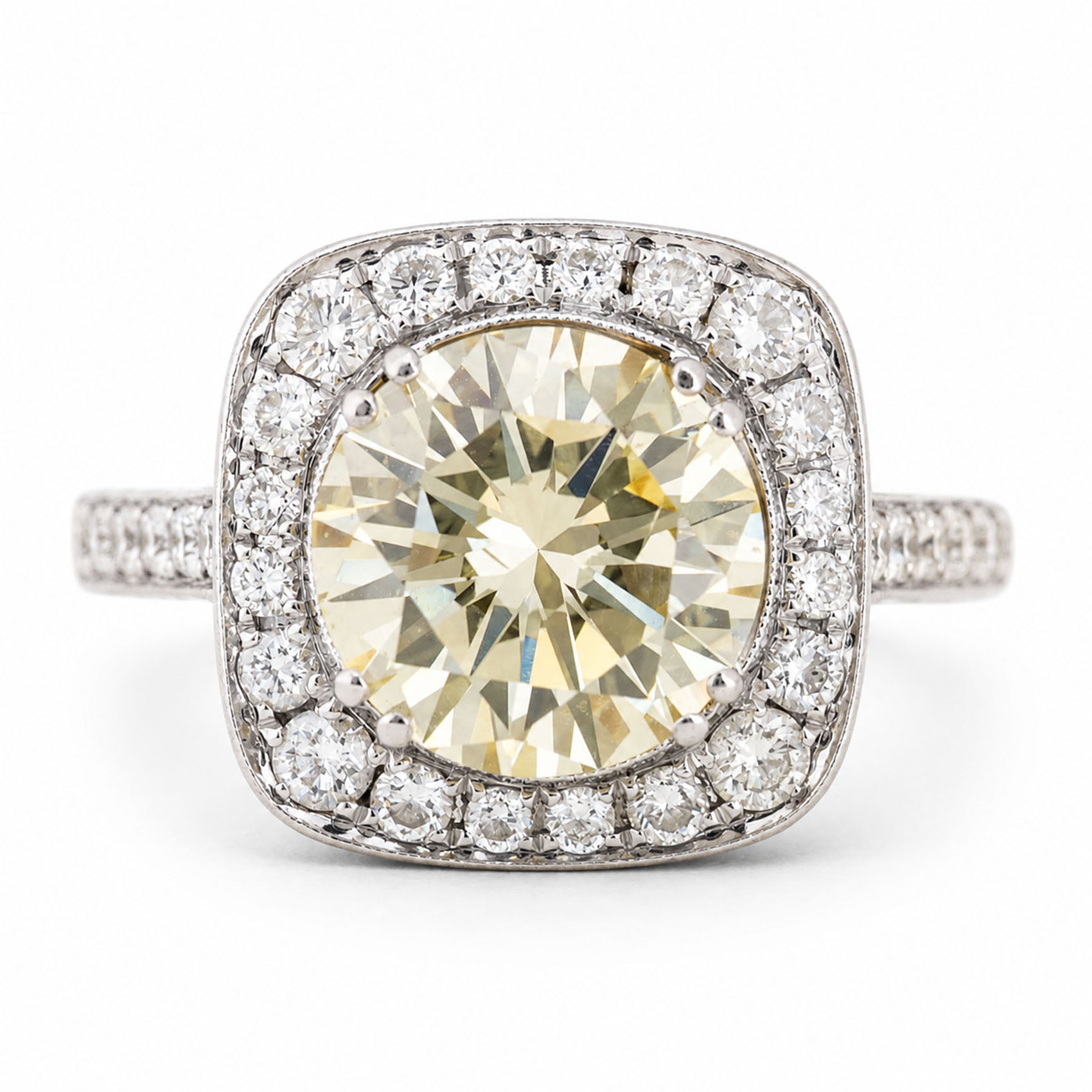 Vintage, 1990s yellow tinted diamond cluster engagement ring in white gold against a plain white background