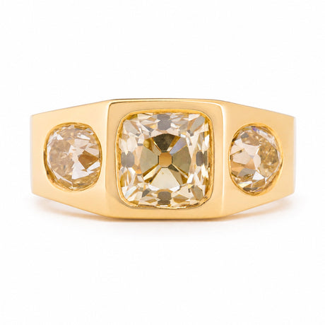 A Vintage, 1970s Peruzzi cut diamond three-stone gypsy ring in yellow gold against a white background.