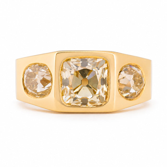 A Vintage, 1970s Peruzzi cut diamond three-stone gypsy ring in yellow gold against a white background.