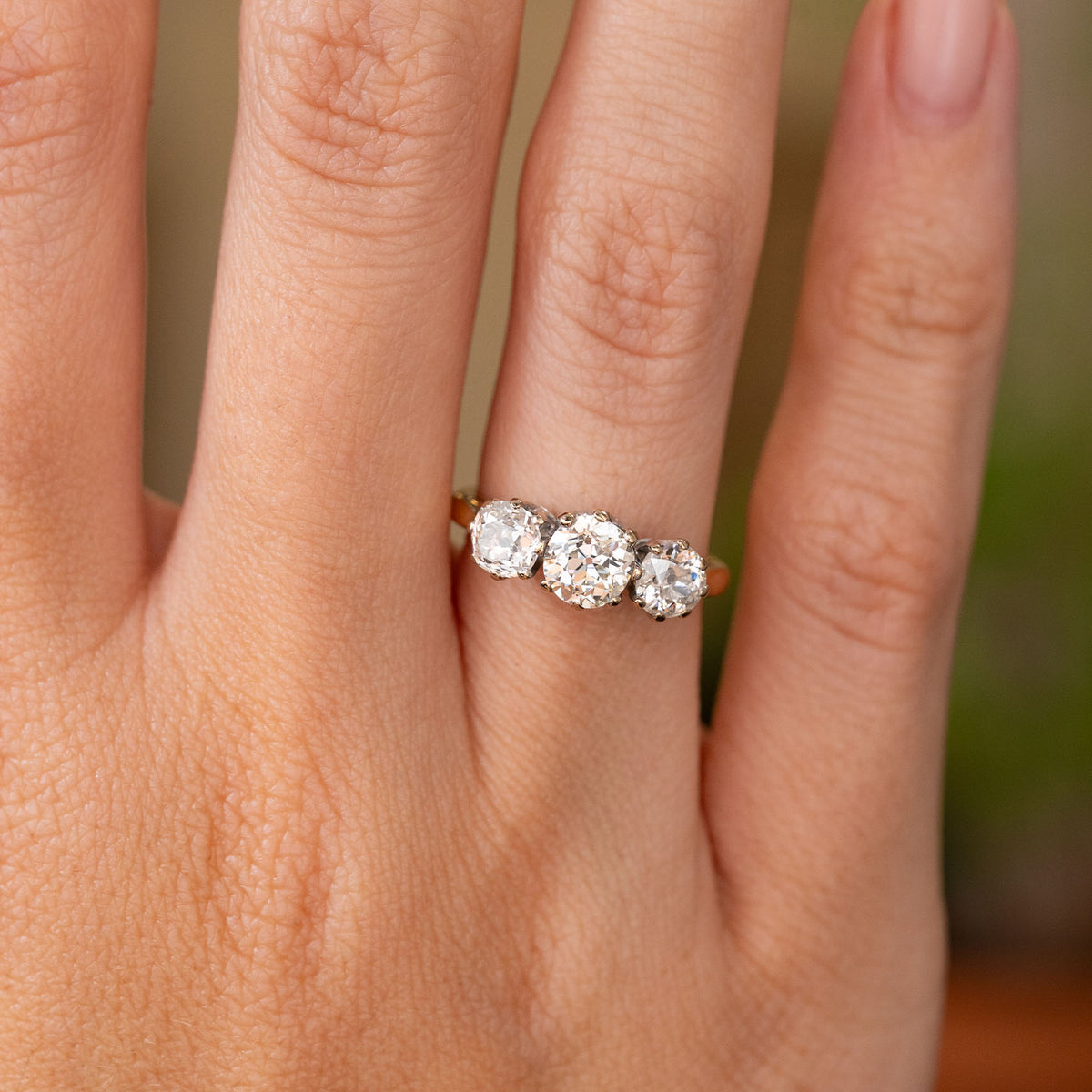 A photo of a Vintage, 1990s old-cut diamond three-stone engagement ring in yellow gold 