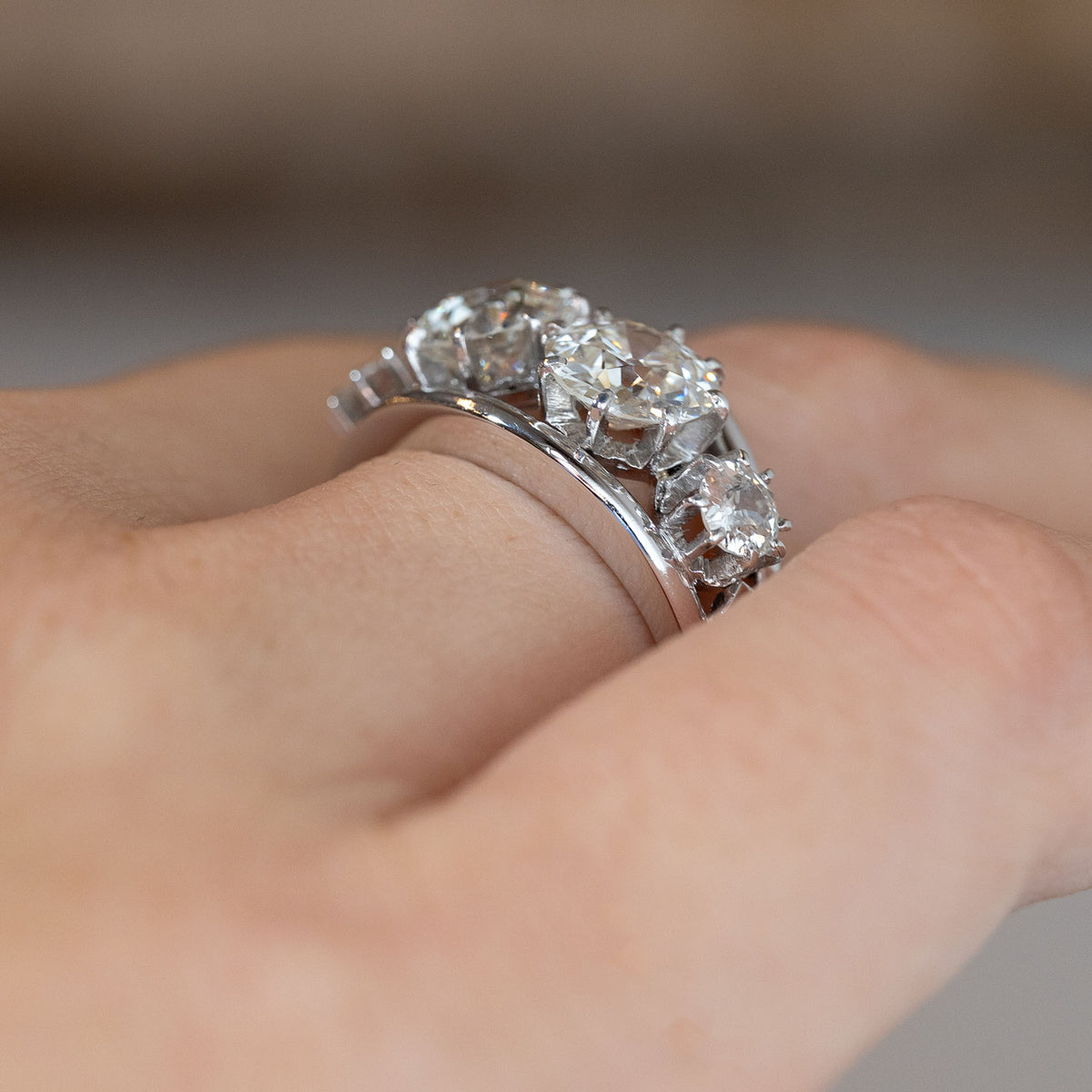 Side-angle view of the 1950s diamond ring worn on a hand, highlighting the raised diamond settings and sculptural white gold band.