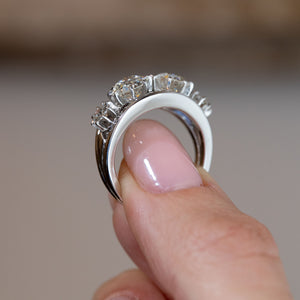 Side profile of the vintage diamond engagement ring, revealing the elevated claw settings and curved white gold and platinum band.