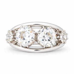 Vintage 1950s old-cut diamond four-stone engagement ring in white gold and platinum, featuring two larger central diamonds and smaller diamond shoulders.