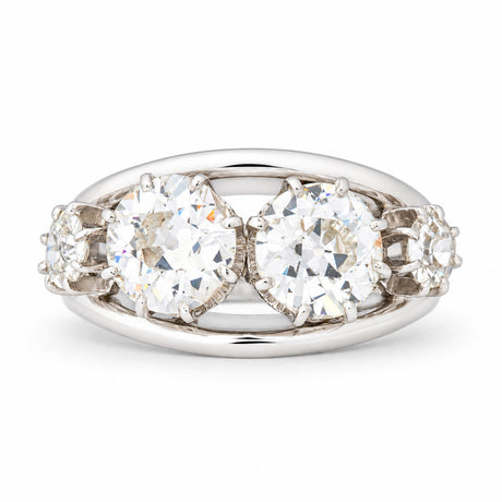 Vintage 1950s old-cut diamond four-stone engagement ring in white gold and platinum, featuring two larger central diamonds and smaller diamond shoulders.