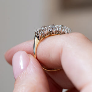 Side profile emphasising the gently curved platinum crown and slender yellow gold band of this antique Edwardian ring.