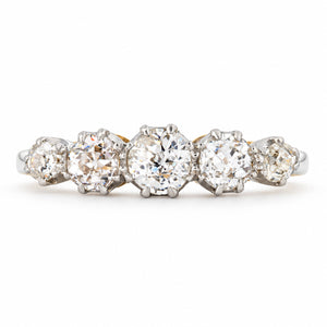 Five graduated old-cut diamonds form an elegant Edwardian engagement ring, claw-set in platinum across a yellow gold band.