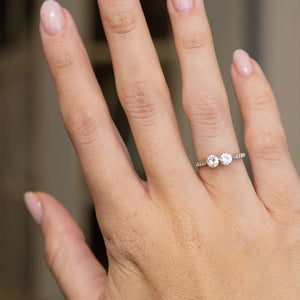 Antique two-stone diamond engagement ring worn on the hand, showing the romantic toi et moi design and sparkling shoulders.