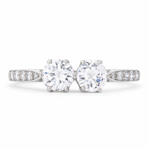 Antique Art Deco diamond toi et moi engagement ring in platinum, set with two round transition-cut diamonds and diamond-set shoulders.