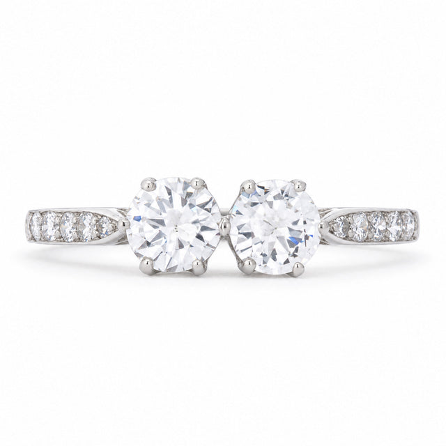 Antique Art Deco diamond toi et moi engagement ring in platinum, set with two round transition-cut diamonds and diamond-set shoulders.
