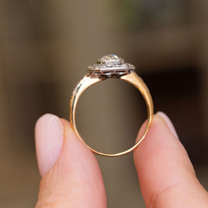Profile view of an Edwardian diamond engagement ring, revealing the raised platinum cluster and polished yellow gold band.