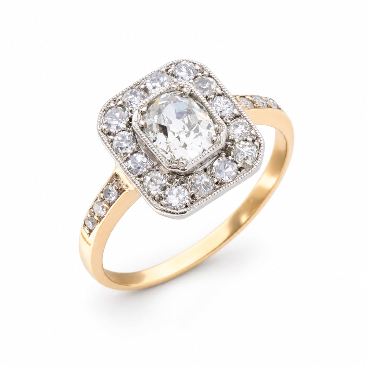Angled product view of an Edwardian diamond engagement ring, featuring a central old-mine cut diamond within a geometric platinum cluster.