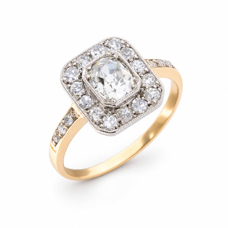 Angled product view of an Edwardian diamond engagement ring, featuring a central old-mine cut diamond within a geometric platinum cluster.