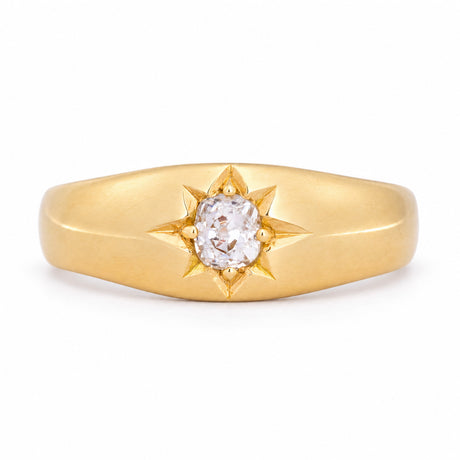 Antique Victorian diamond solitaire gypsy engagement ring in yellow gold, featuring a central diamond within an engraved star setting.