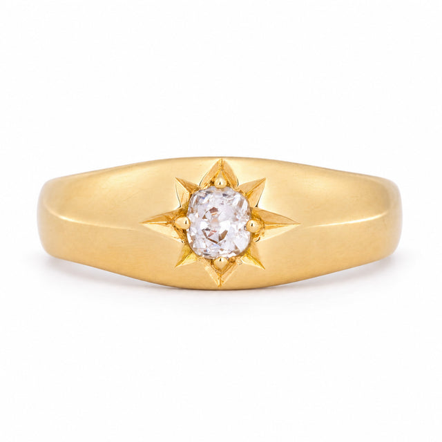 Antique Victorian diamond solitaire gypsy engagement ring in yellow gold, featuring a central diamond within an engraved star setting.
