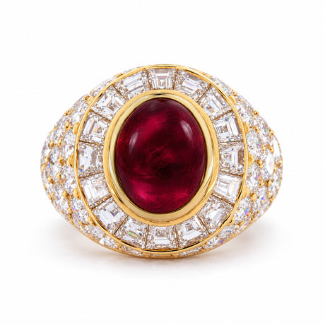 Vintage Asprey cocktail ring in yellow gold, centred with an oval cabochon ruby and surrounded by tapered step-cut and round brilliant diamonds.