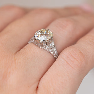Side angle of the antique engagement ring, revealing the elevated centre stone and diamond-set filigree shoulders.