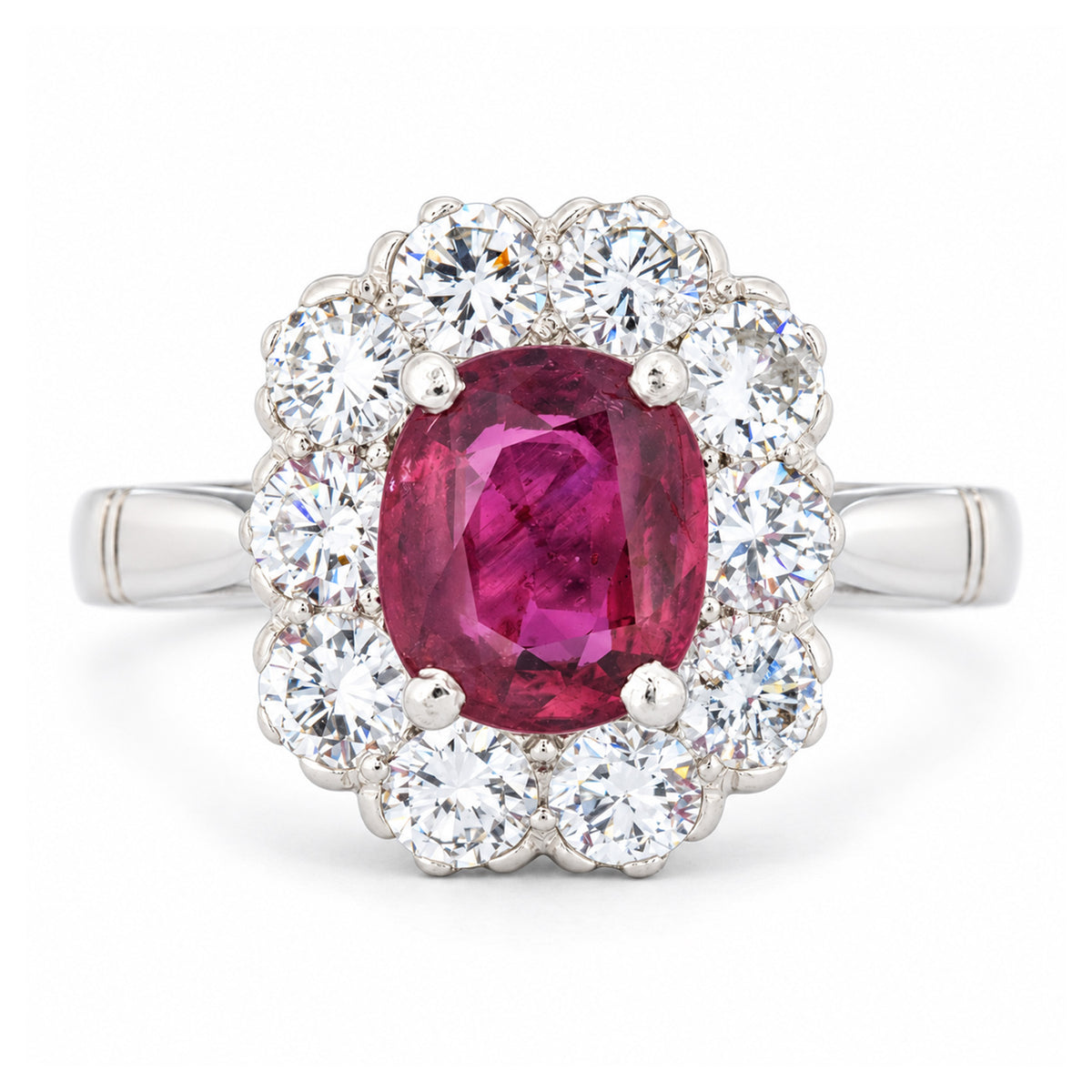 Front view of a vintage 1960s engagement ring featuring a vibrant oval ruby encircled by brilliant-cut diamonds in polished white gold.