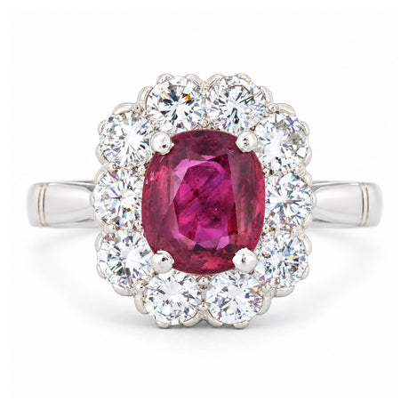 Front view of a vintage 1960s engagement ring featuring a vibrant oval ruby encircled by brilliant-cut diamonds in polished white gold.