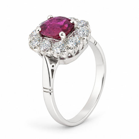 Three-quarter studio view of the ruby and diamond halo ring, showcasing its elevated cluster setting and elegant white gold band.