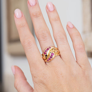 Victorian ruby snake ring worn on the hand, showcasing its bold intertwined yellow gold form.