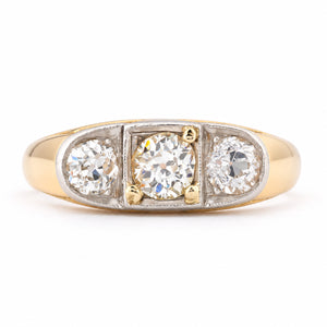 Antique Edwardian diamond three-stone engagement ring in yellow gold and platinum, featuring three round old-cut diamonds in a platinum setting with a broad yellow gold band.