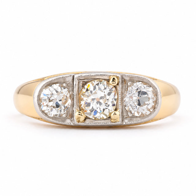 Antique Edwardian diamond three-stone engagement ring in yellow gold and platinum, featuring three round old-cut diamonds in a platinum setting with a broad yellow gold band.