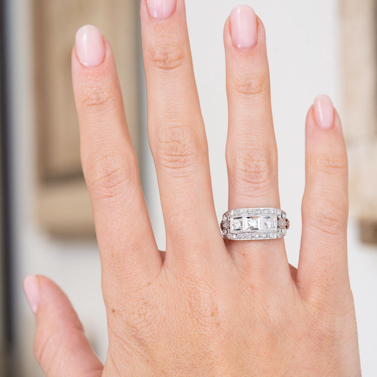 Antique diamond engagement ring worn on the hand, displaying the distinctive elongated Art Deco cluster.