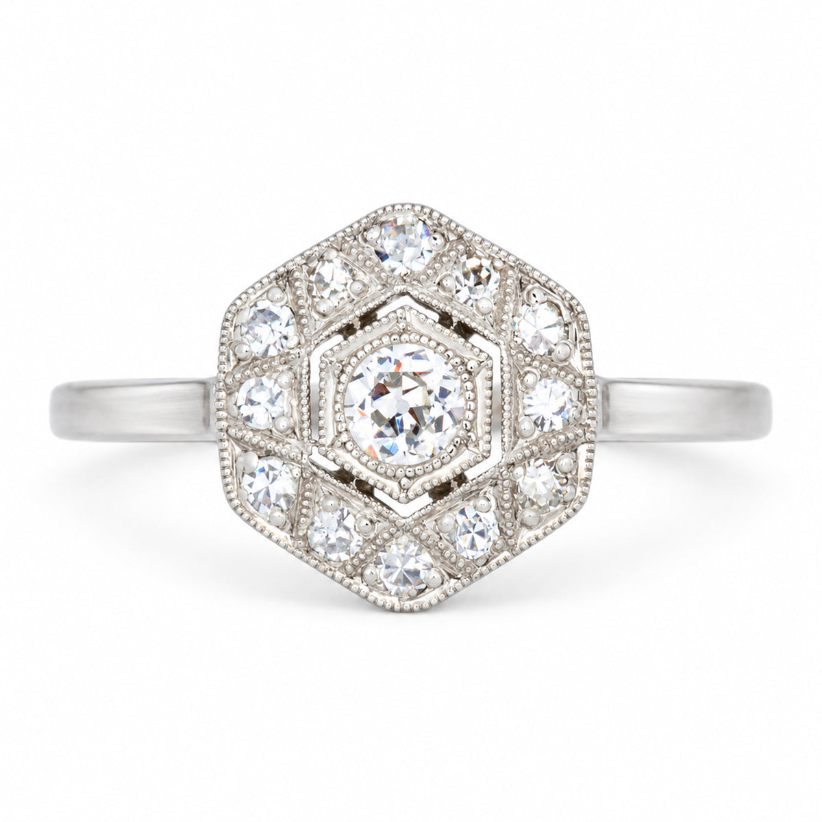 Antique Art Deco diamond cluster engagement ring in white gold and platinum, set with old-cut and single-cut diamonds in a geometric hexagonal design.