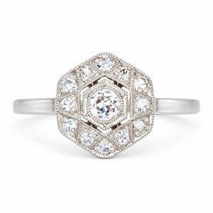 Antique Art Deco diamond cluster engagement ring in white gold and platinum, set with old-cut and single-cut diamonds in a geometric hexagonal design.