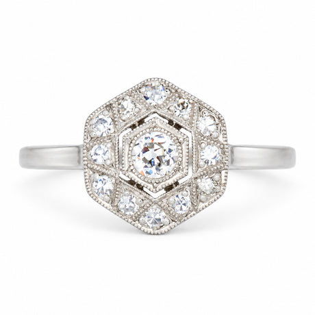 Antique Art Deco diamond cluster engagement ring in white gold and platinum, set with old-cut and single-cut diamonds in a geometric hexagonal design.